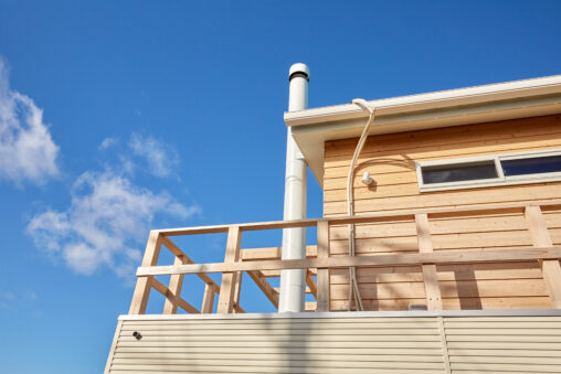 木造で白い煙突がある家です